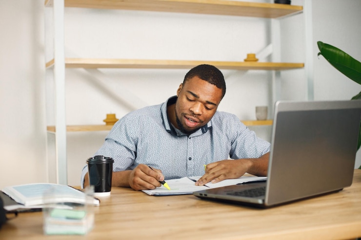 https://motivated-counseling.com/wp-content/uploads/2022/09/black-male-entrepreneur-sitting-office-using-laptop-writing-notes_1157-51853.jpg